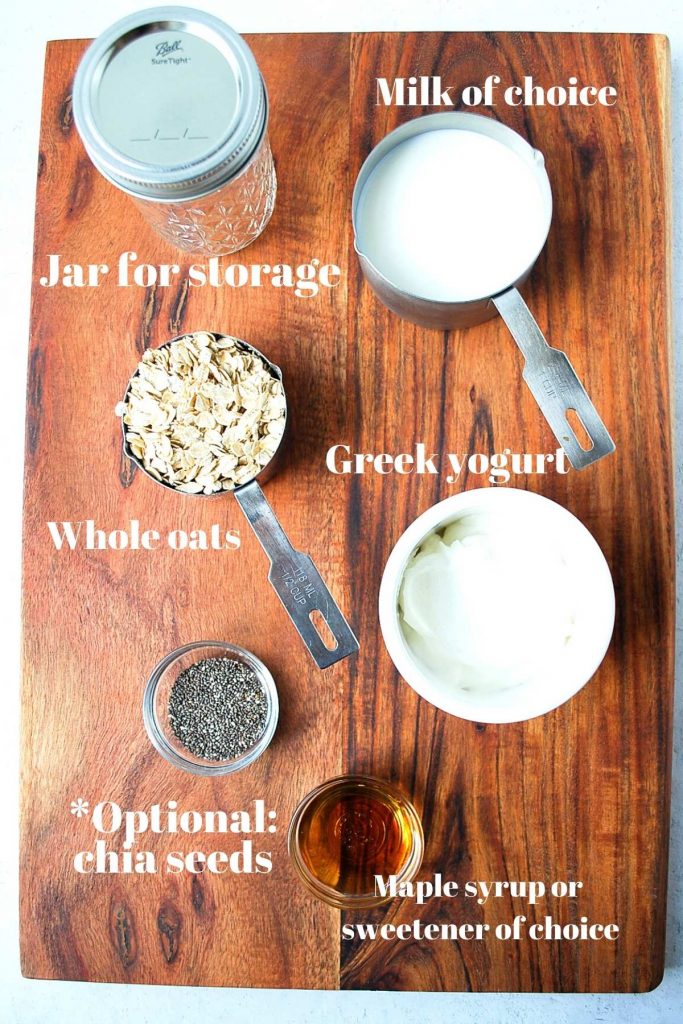 Greek yogurt, chia seeds, oats, Mason jar, and milk on a wood backdrop