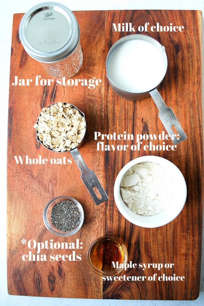 Protein powder, chia seeds, oats, Mason jar, and milk on a wood backdrop