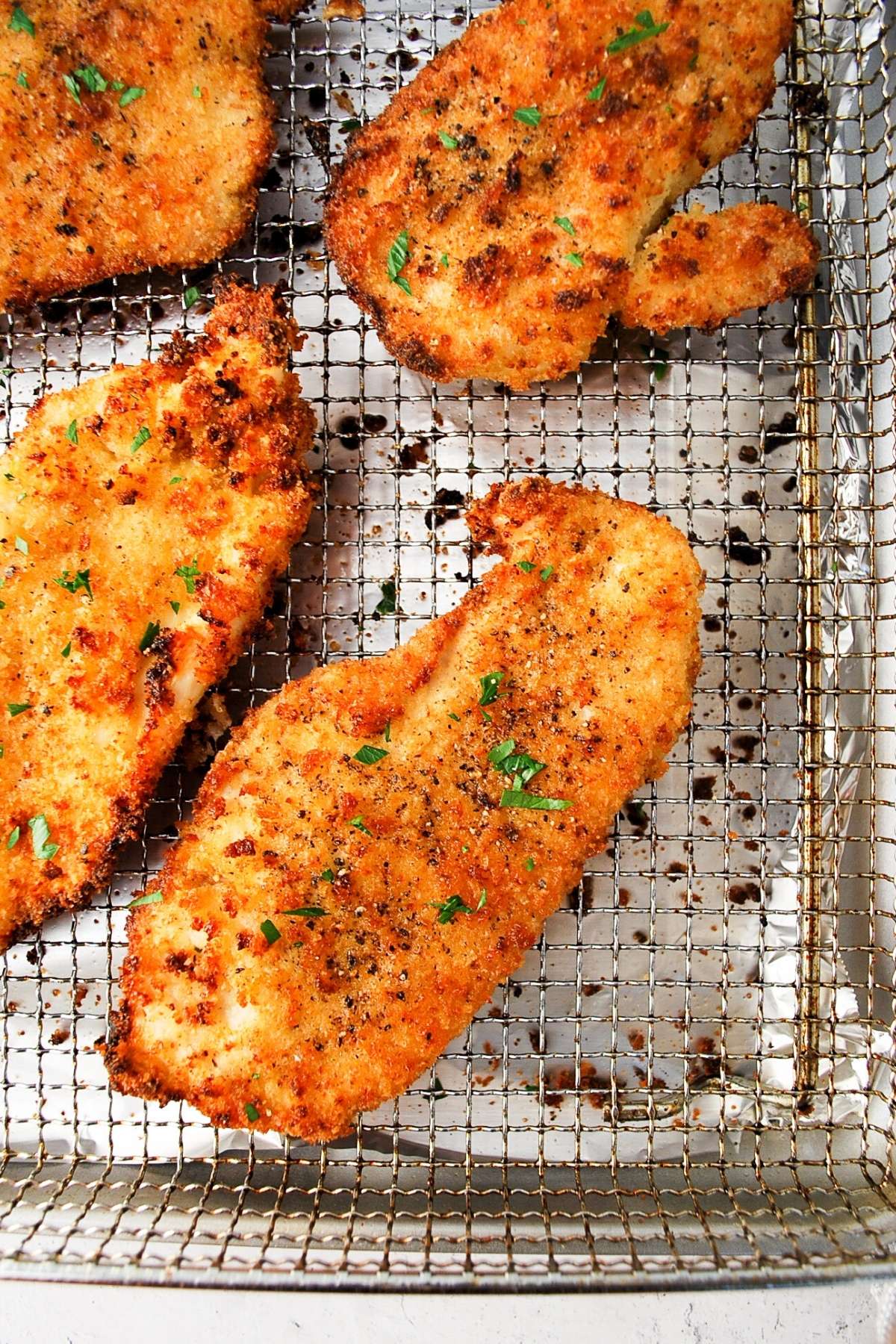 chicken cutlets on an air fryer baking sheet