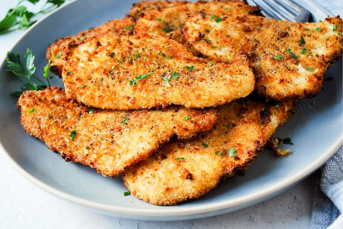 plate of cooked air fryer chicken cutlets sprinkled with fresh parsley