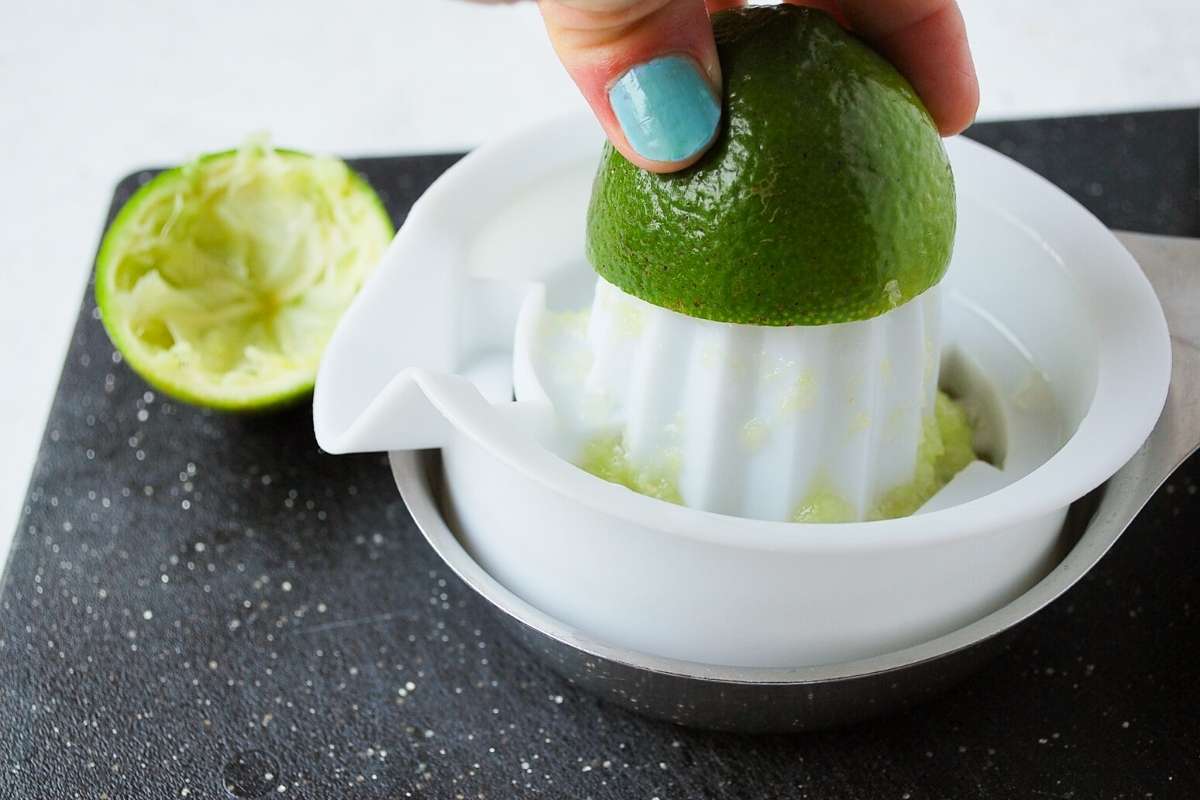 juicing a fresh lime on a cutting board