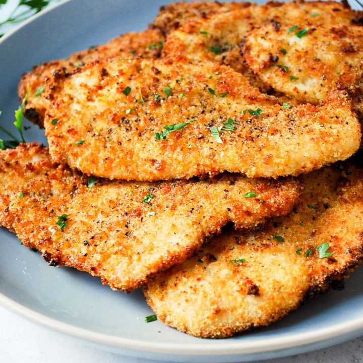 close up of juicy air fryer chicken cutlets on a grey plate