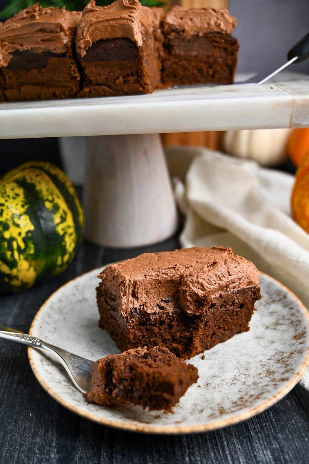 a frosted pumpkin chocolate cake with a bite out of it