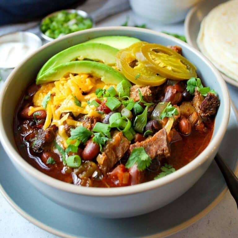 close up of a bowl of brisket chili loaded with toppings