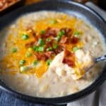 a spoonful of potato soup with cheese and bacon