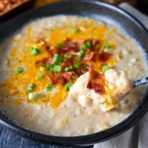 a spoonful of potato soup with cheese and bacon