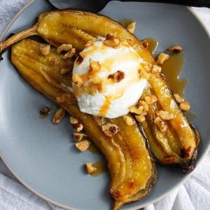 close up of an air fried banana with frozen Greek yogurt, walnuts, and sugar-free caramel drizzle on a plate