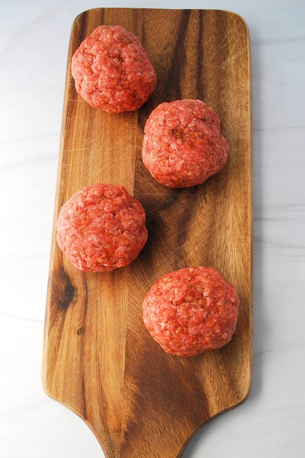 balls of ground beef on a cutting board