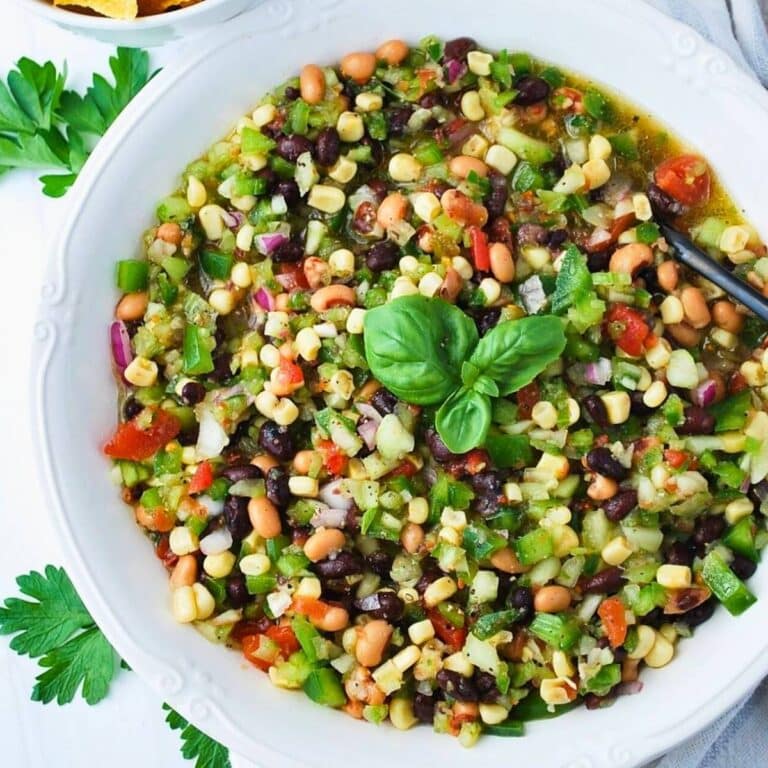 a bowl of redneck caviar with fresh basil on top