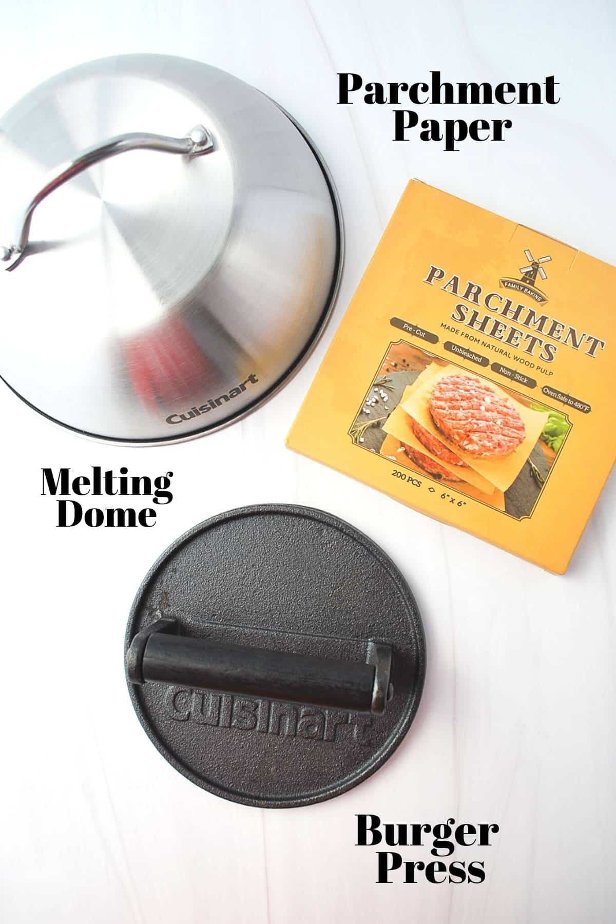 melting dome, burger press, and parchment sheets on a counter