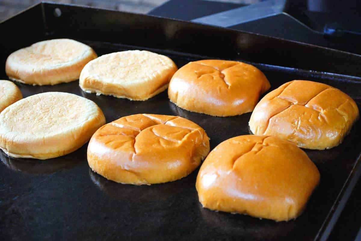 brioche buns toasting on a flat top griddle