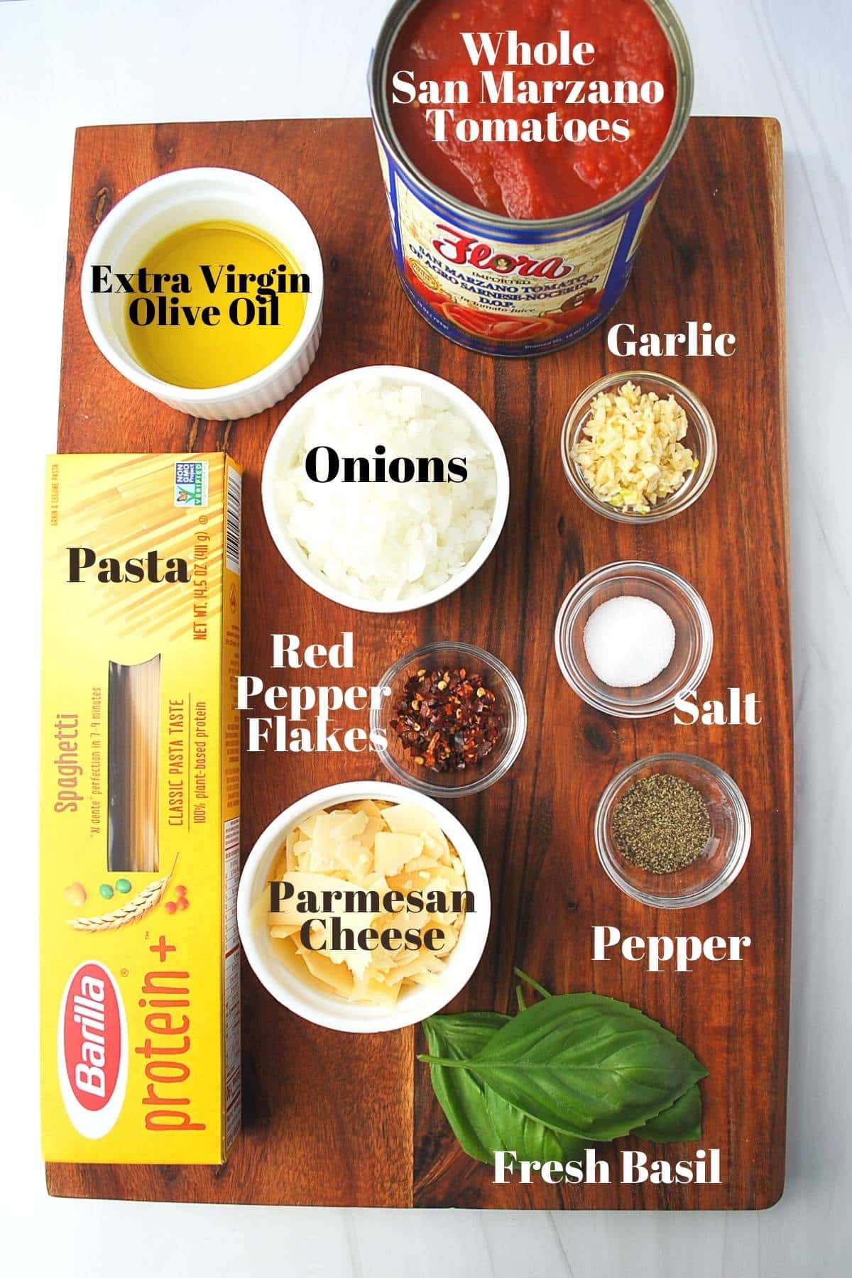 ingredients for spaghetti arrabbiata measured out on a wooden cutting board