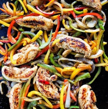 overhead photo of cooked chicken fajitas on a Blackstone griddle ready to serve