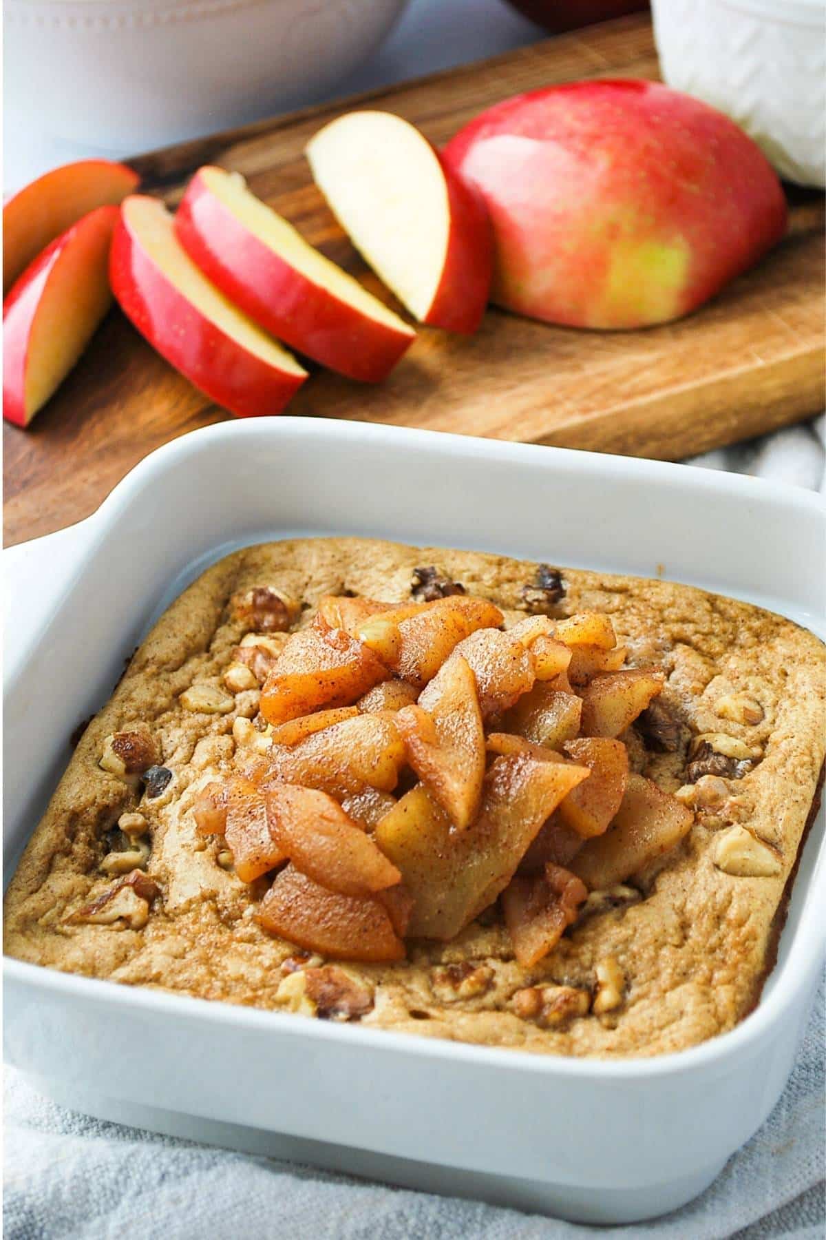 a pan of baked apple oats with cinnamon apples and walnuts