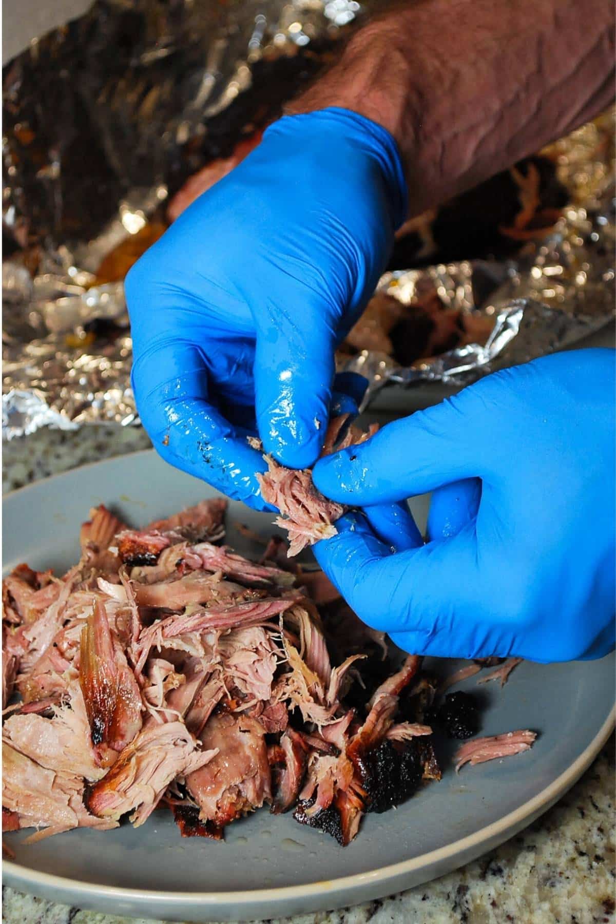 shredding a pork butt onto a plate