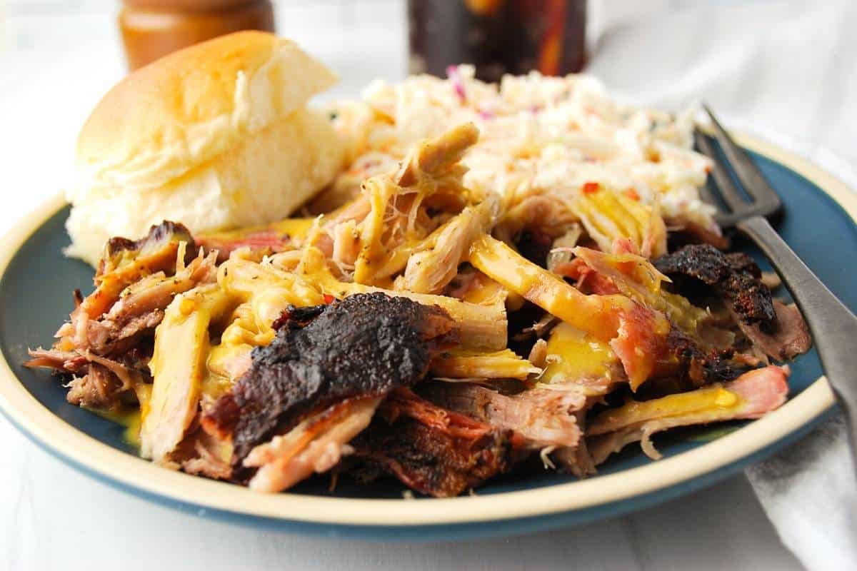 plate of pulled pork BBQ with slaw and a roll
