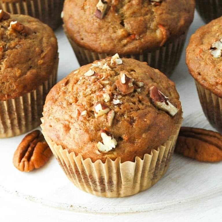 banana muffins with carrots topped with toasted pecans on a platter