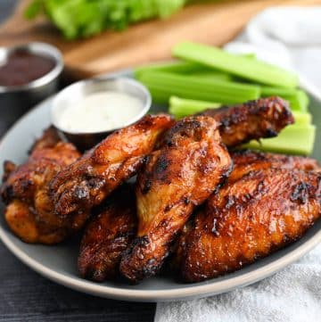BBQ chicken wings on a gray plate with celery and ranch