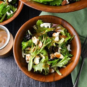 salad with almonds, dried cherries, and feta in a wood bowl