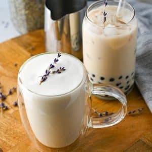 a mug of lavender milk tea with a boba lavender tea behind it