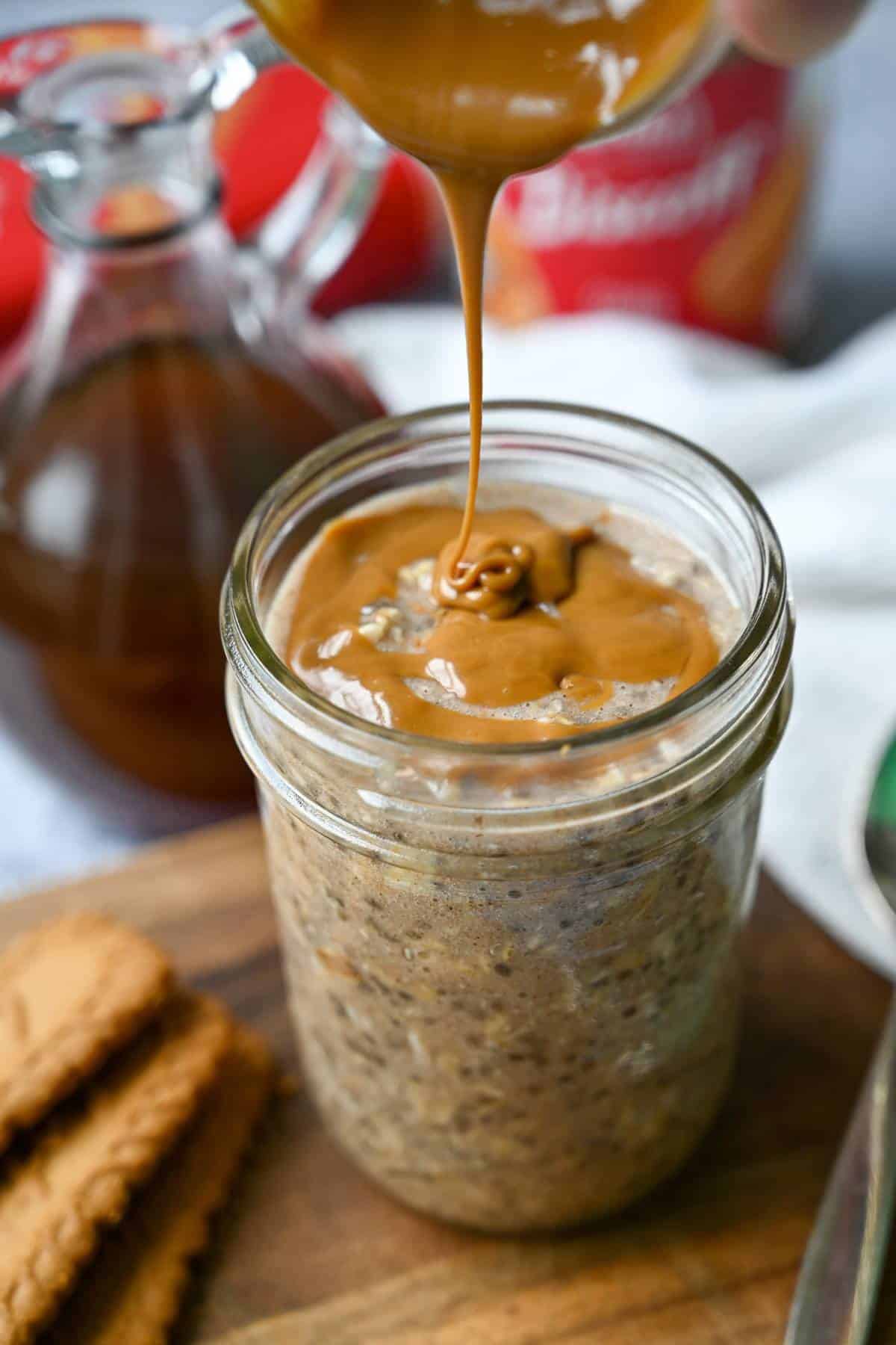 pouring cookie butter on top of protein overnight oats