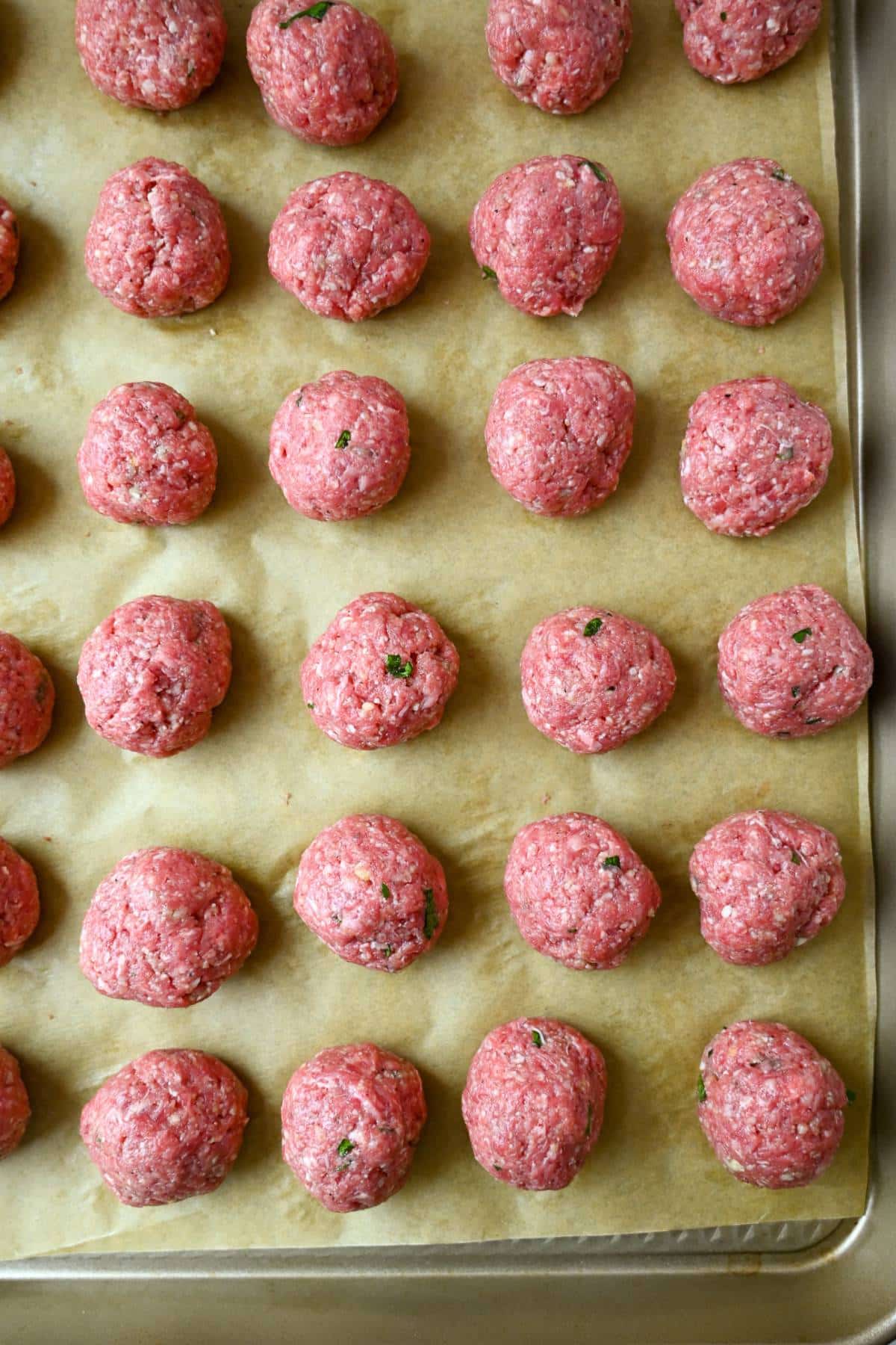 bison meatballs rolled out on parchment paper