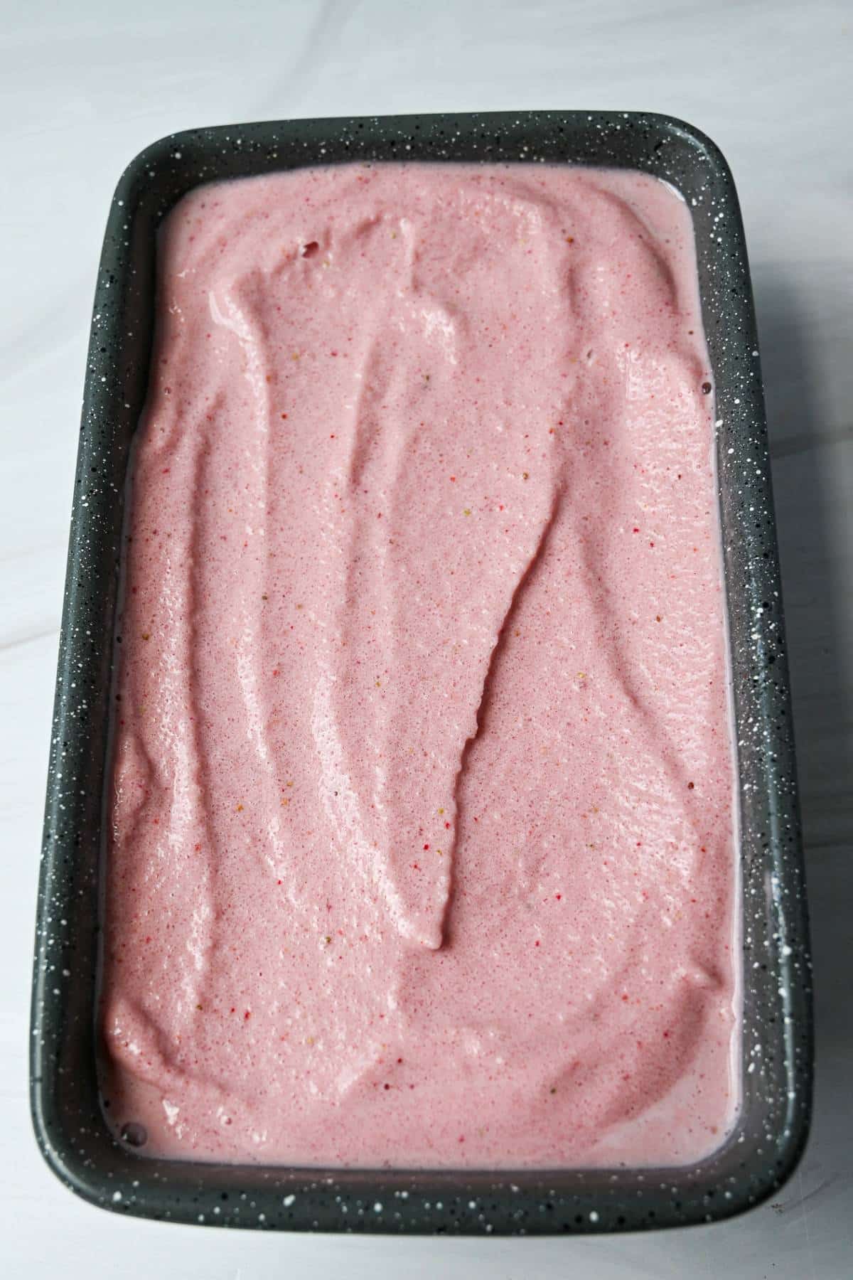 soft serve strawberry ice cream in a loaf pan to freeze