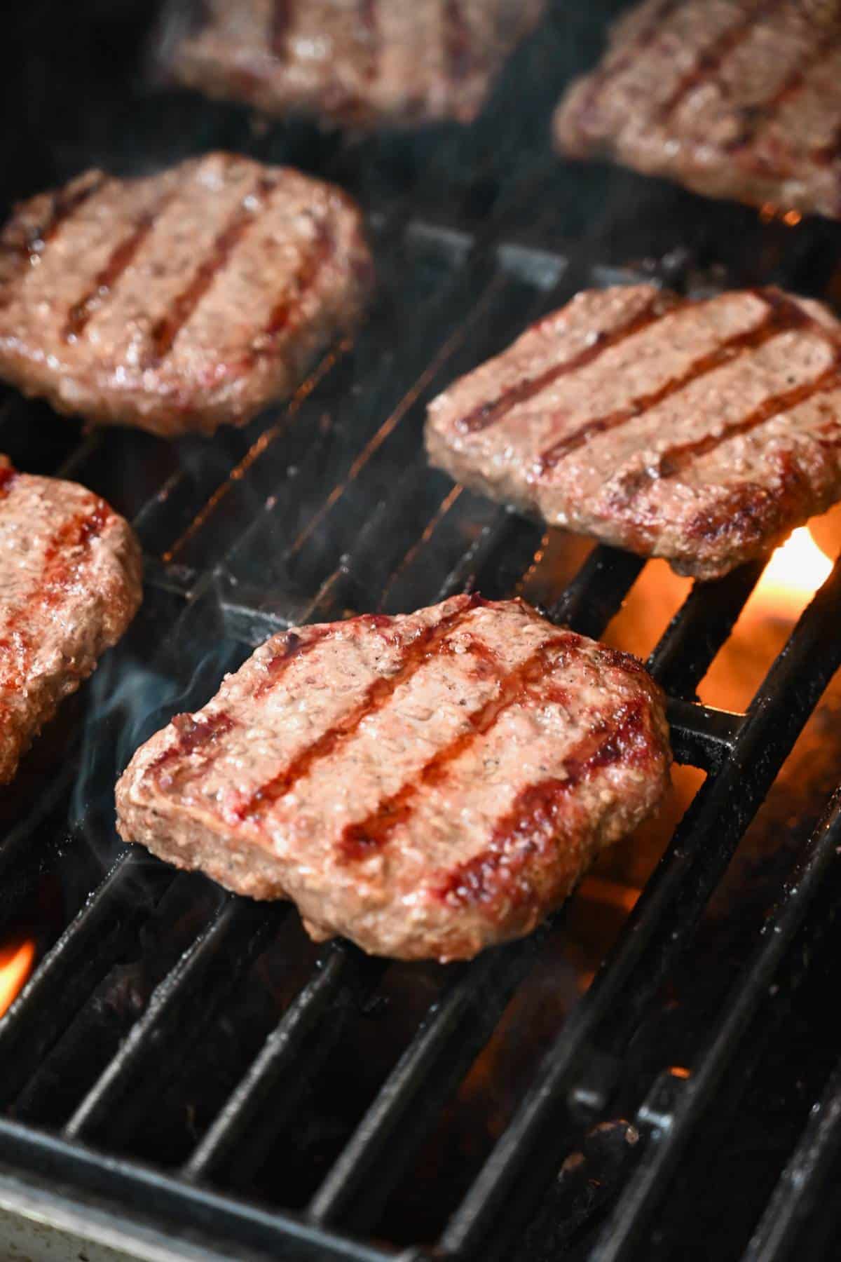 burgers cooking on a gas grill
