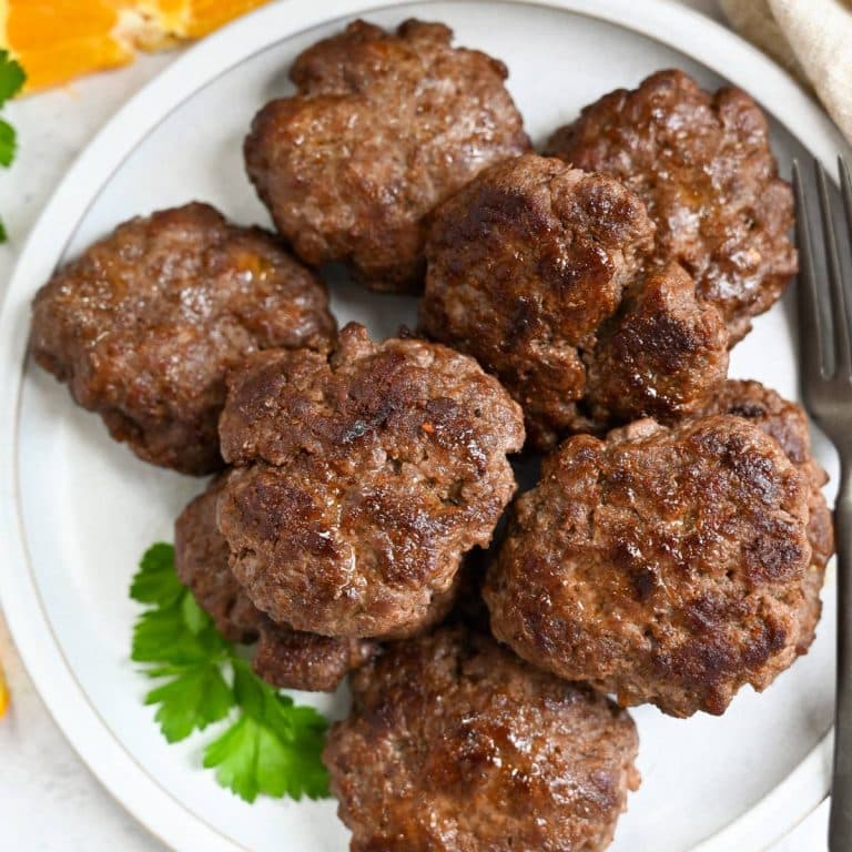 close up of lean beef sausage patties on a plate with parsley