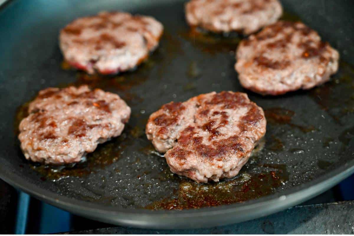 cooked beef sausage in a skillet lightly browned on top