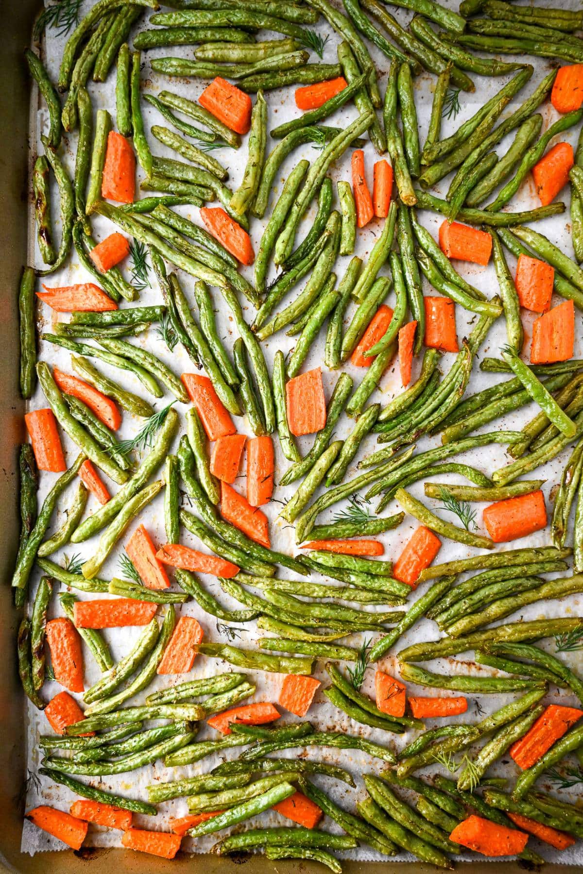 cooked green beans and carrots that were roasted on a baking sheet