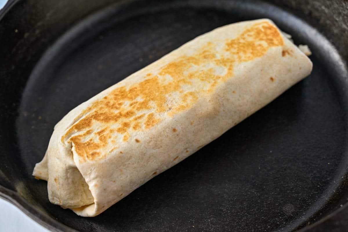 a burrito toasted in a cast iron skillet