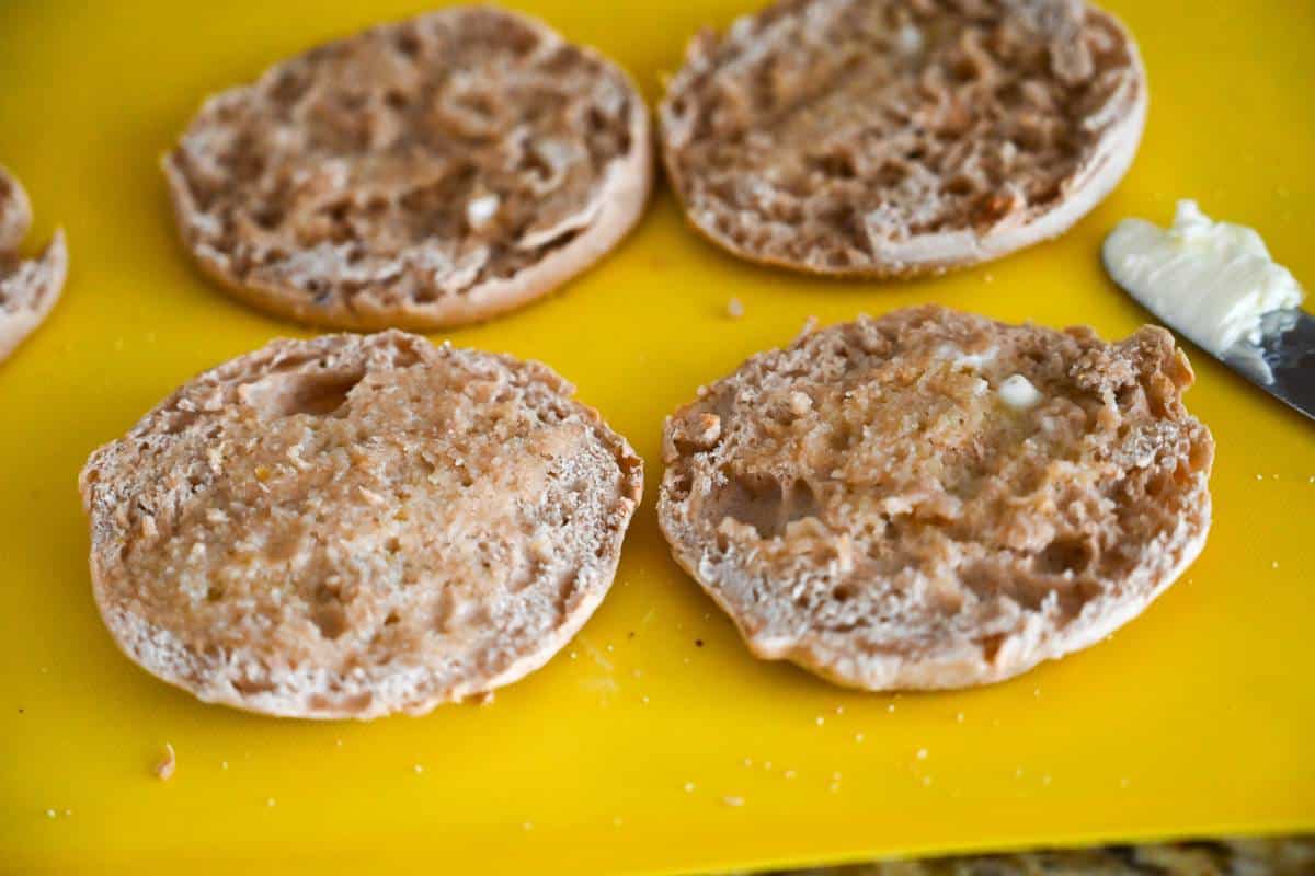 topping toasted english muffins with butter spread