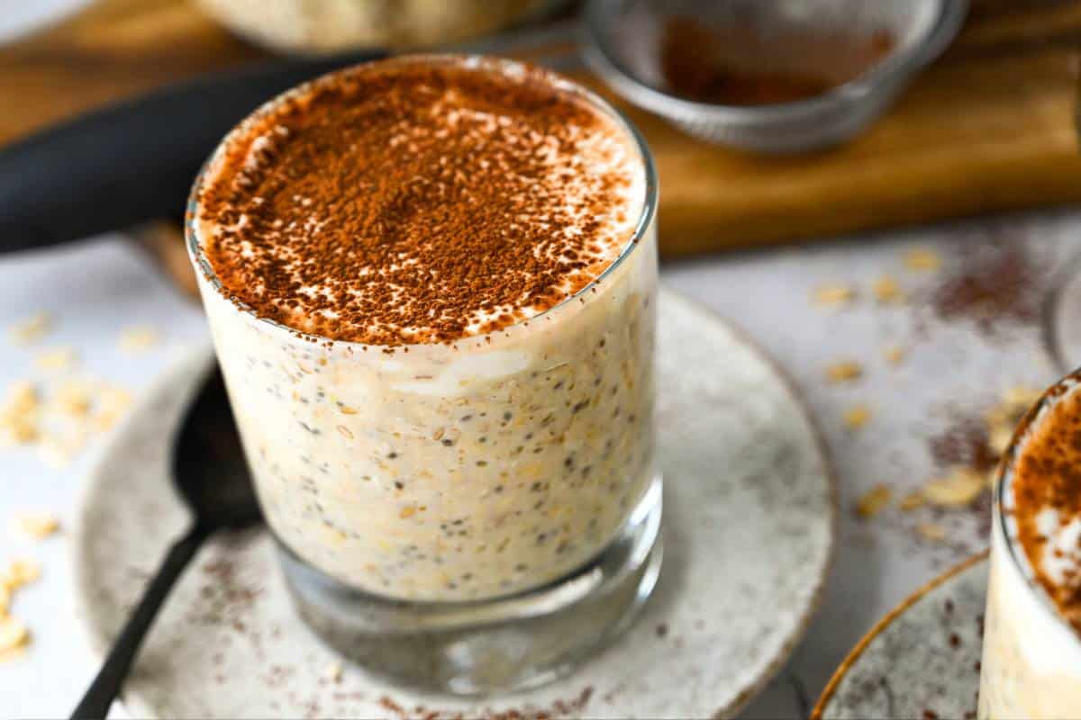 layered tiramisu high protein oats with dusted cocoa on top with dusted cocoa and oats around it