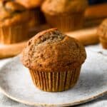 a muffin on a plate with muffins behind it