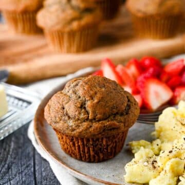a buckwheat banana muffin on a plate with eggs and berries