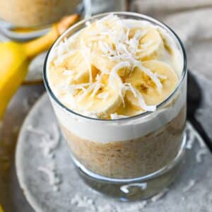 banana pudding inspired oats in a glass with a banana next to it