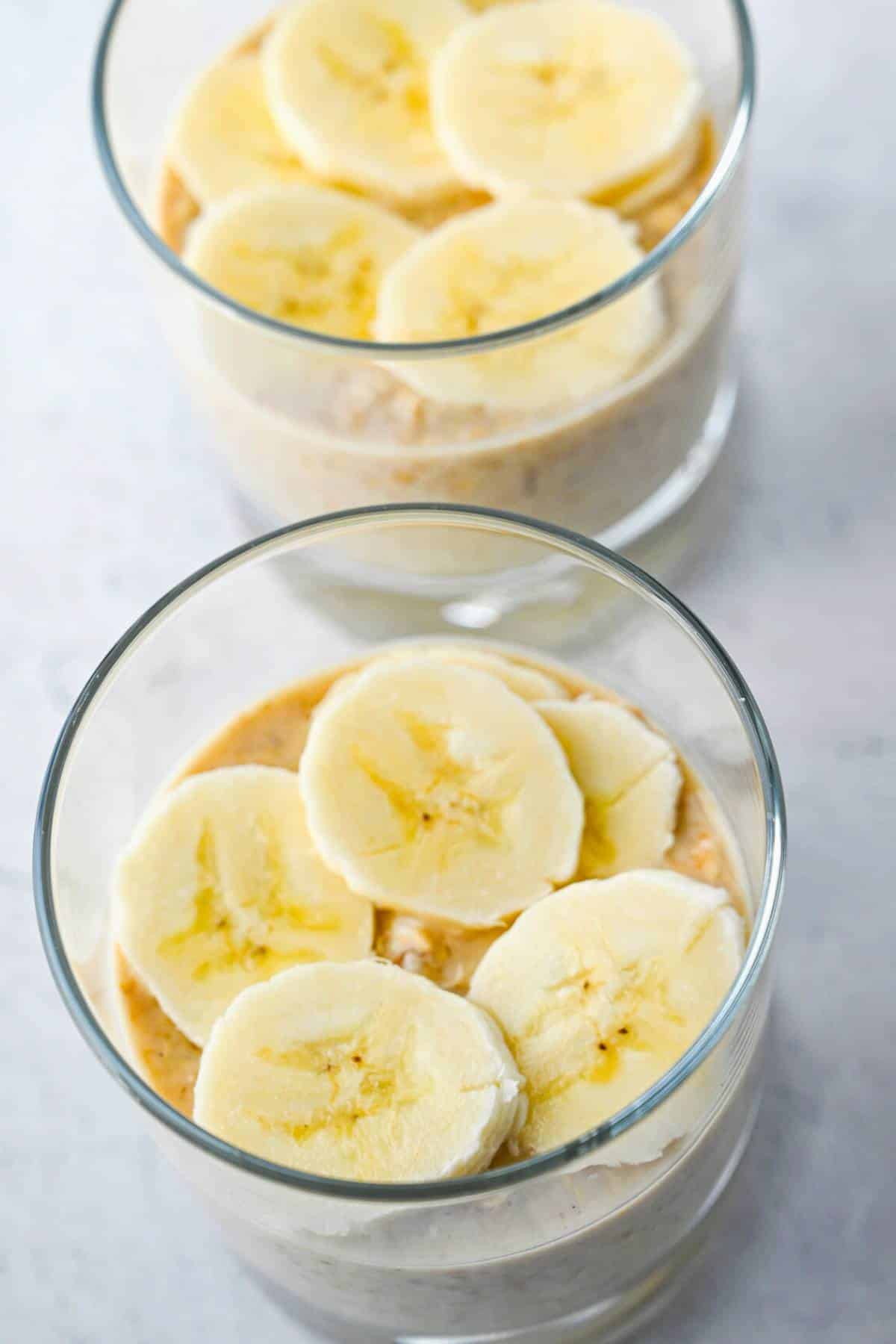 overnight oats in a low ball glass topped with sliced banana