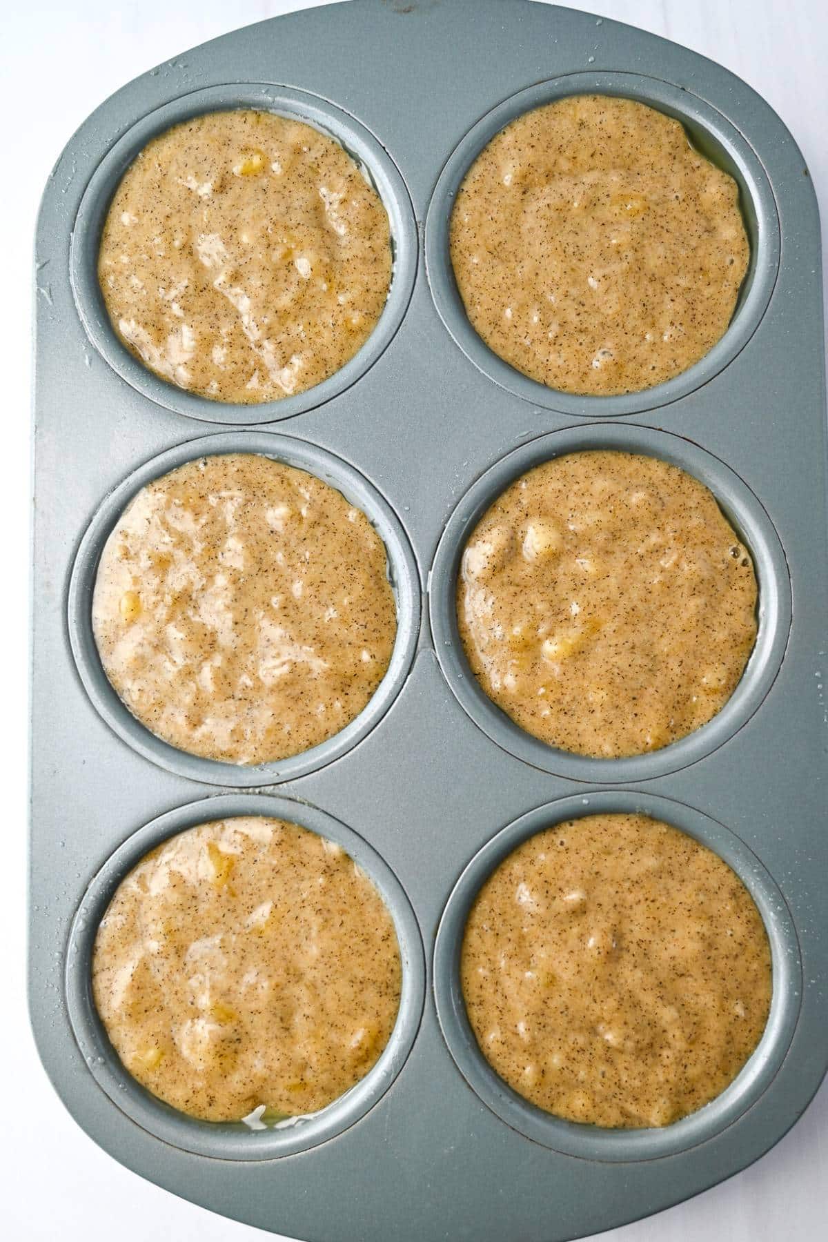 banana muffin batter in a muffin pan ready to bake