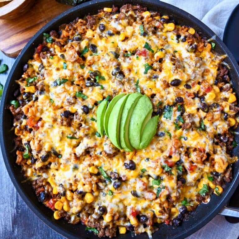 a baked taco skillet with sliced avocado on top