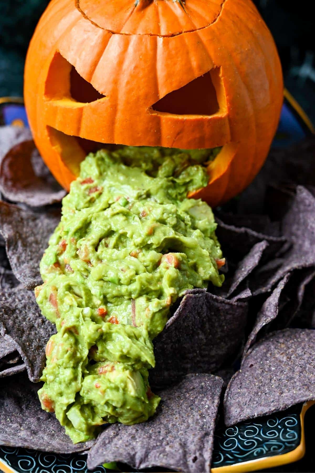 close up of a carved pie pumpkin puking guacamole 