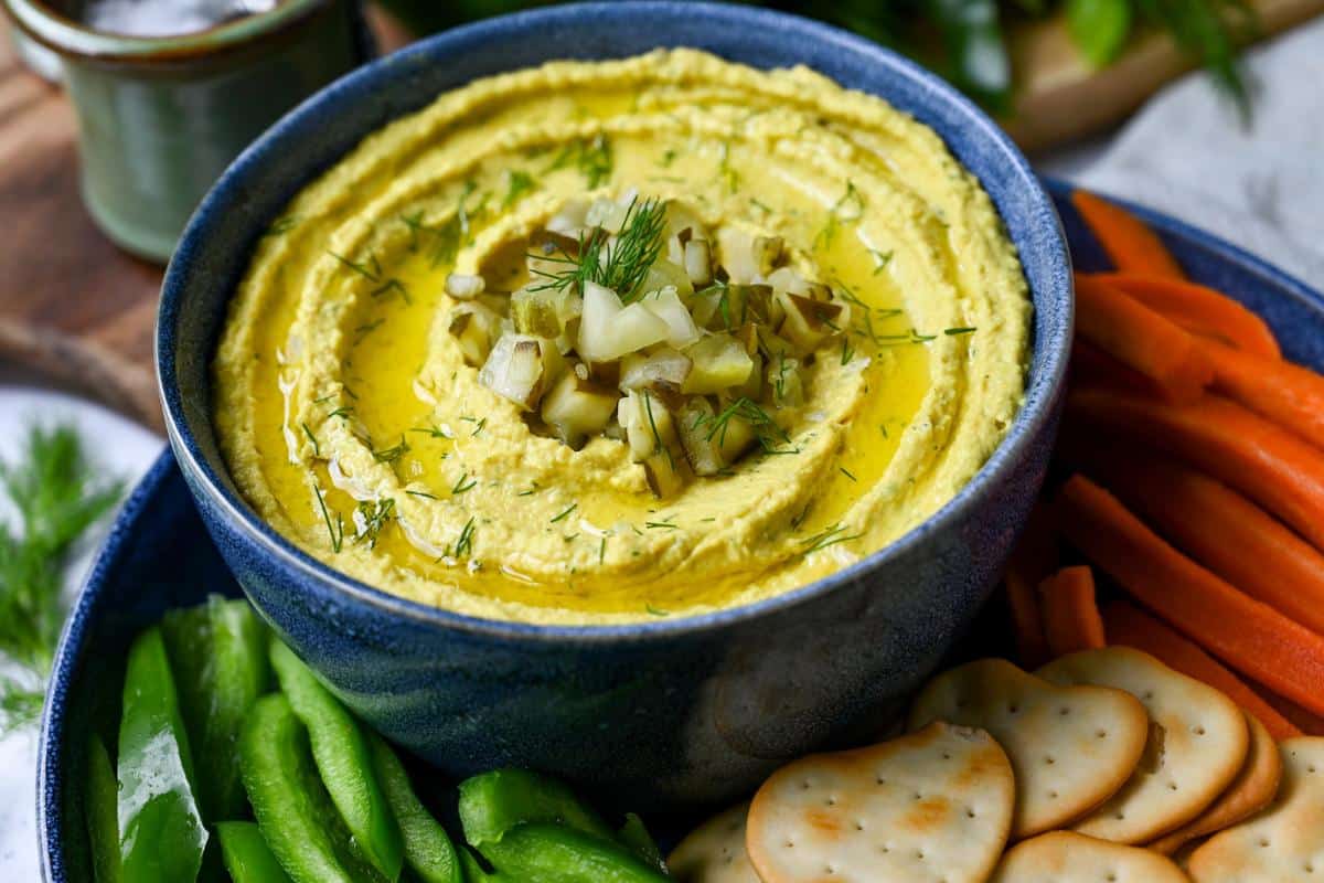 a platter of veggies and dill hummus in a blue bowl