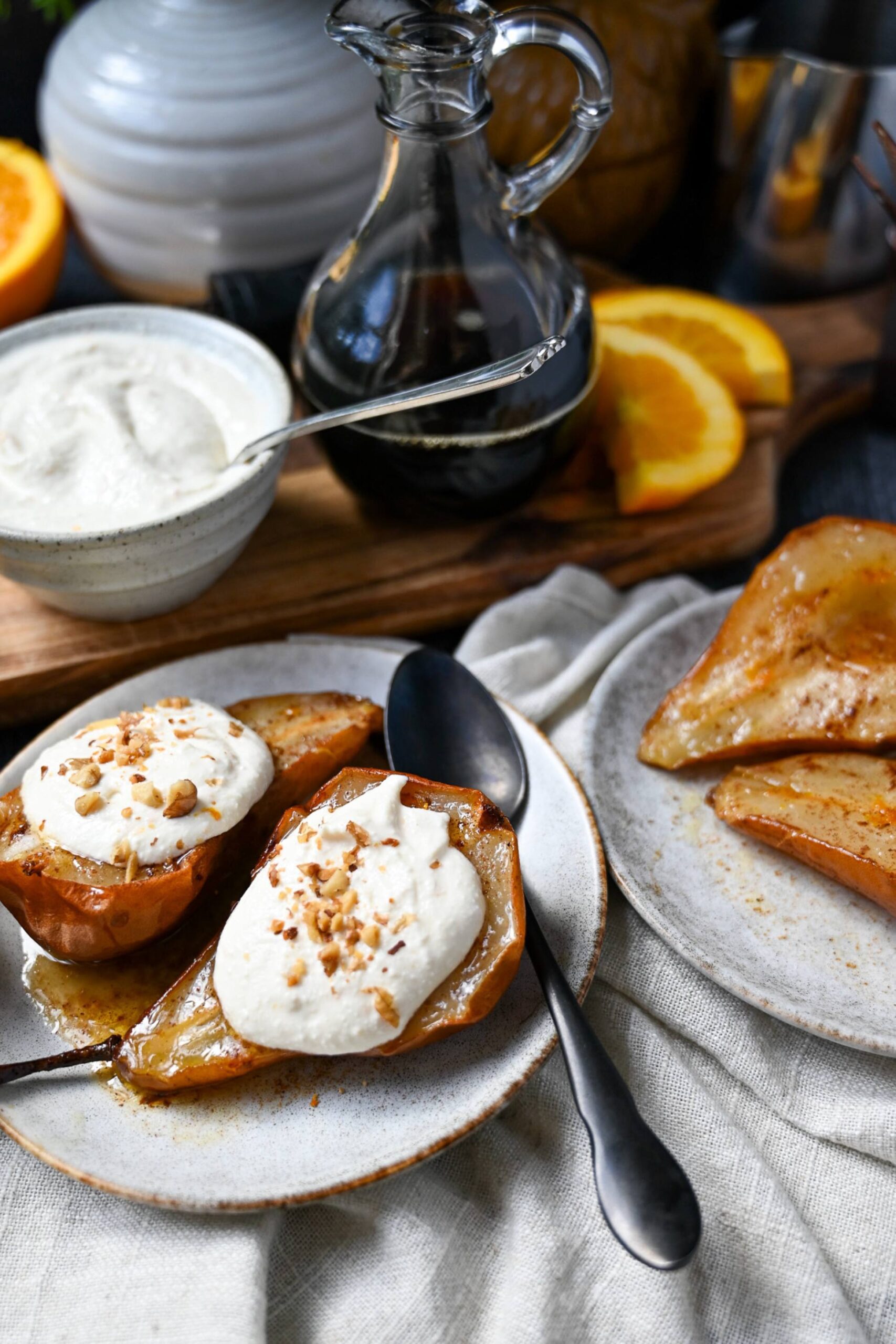 two plates with two air fried pear halves with a maple butter topping and whipped cottage cheese topped on one plate of pears