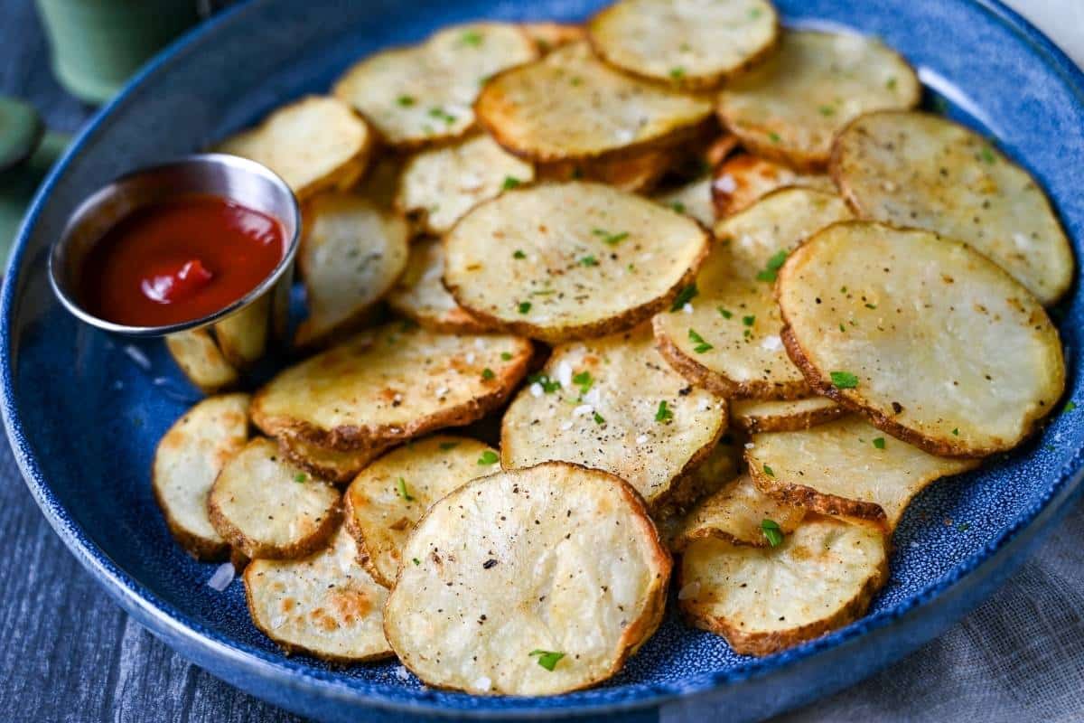 a blue plate full of air fryer chips with ketchup