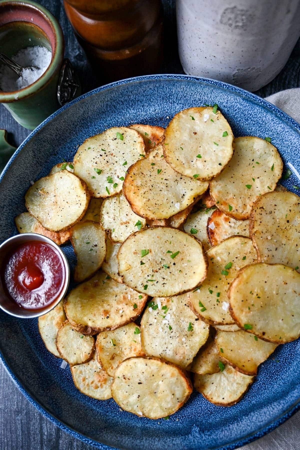 looking down at a plate of homemade air fryer potato chips with ketchup