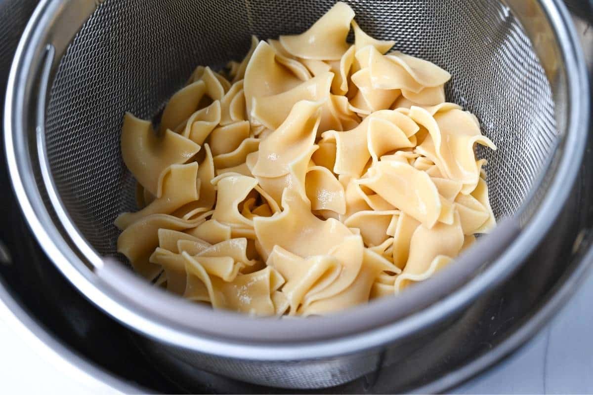 cooked egg noodles in a strainer basket