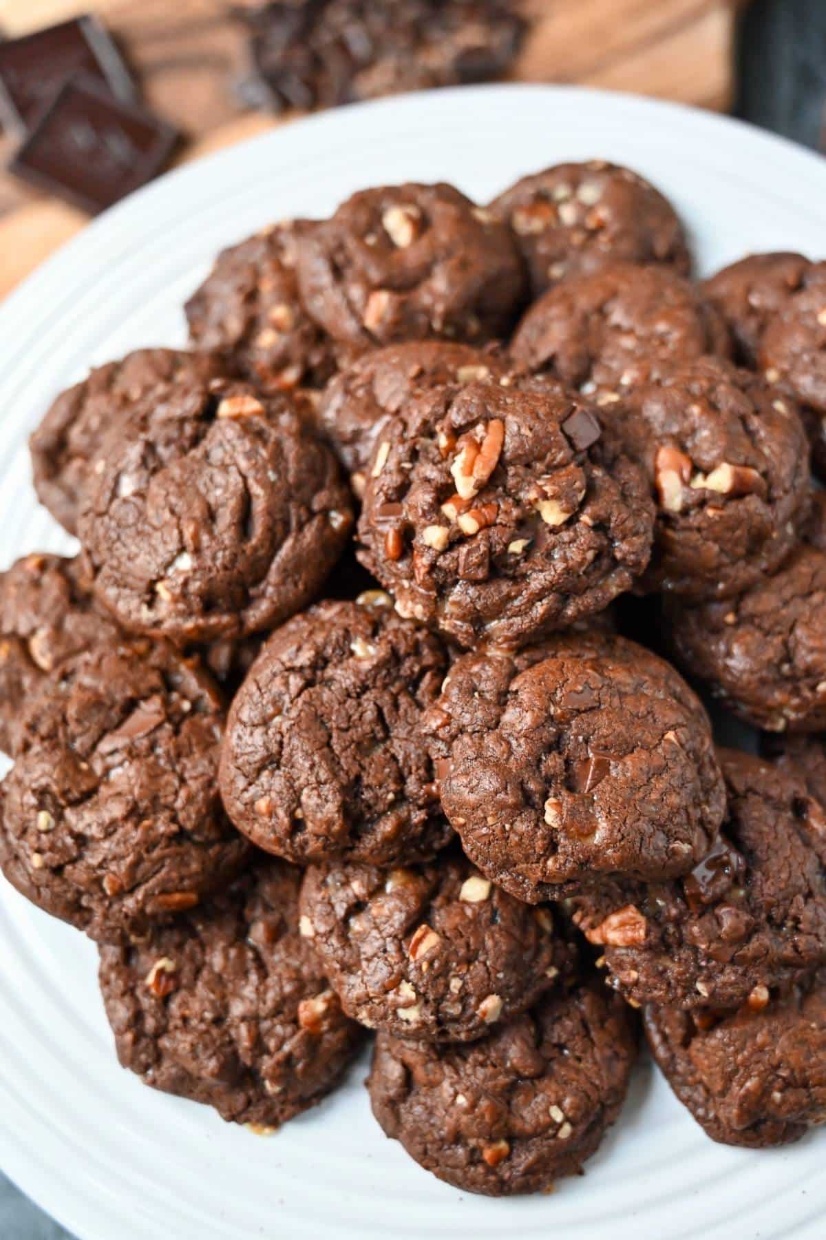 a platter of chocolate cookies with toffee, pecans, and chocolate chunks