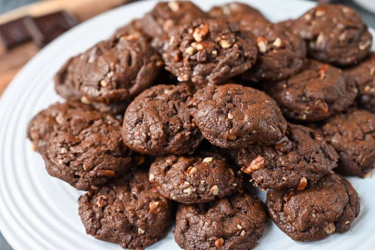 a platter of chocolate crunch cookies with chopped chocolate bar in the background