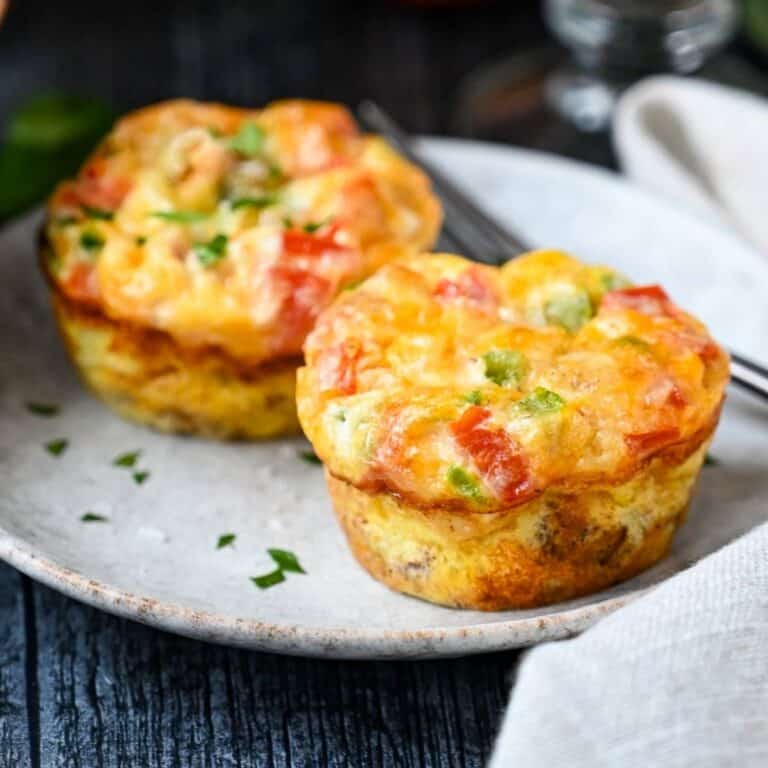 close up of two egg muffins on a plate with a fork