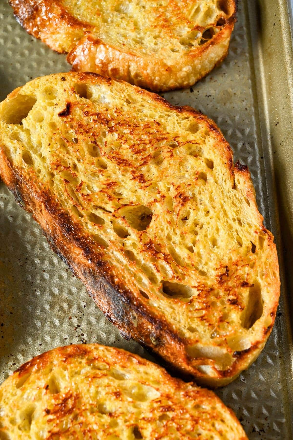 slices of sourdough boule french toast cooked on a baking sheet